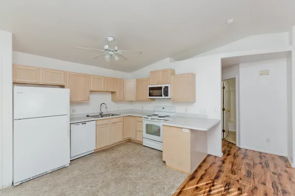 a kitchen with white cabinets and white appliances