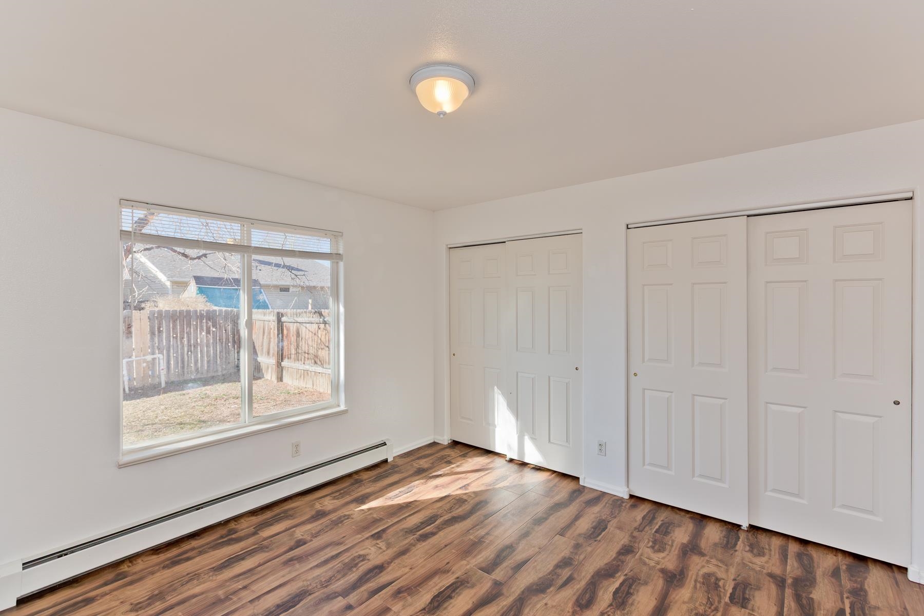 513 April Lane, Unit A Grand Junction, CO 81504 - Photo 17 of 31 a view of an empty room with wooden floor and a window