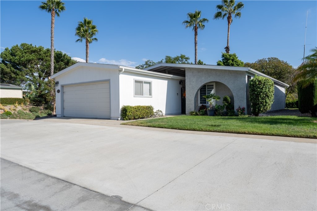 a front view of a house with a yard and a garage