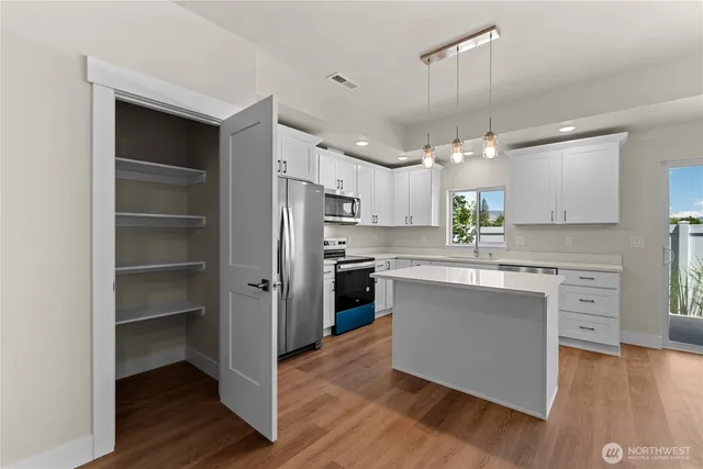 a kitchen with white cabinets and stainless steel appliances