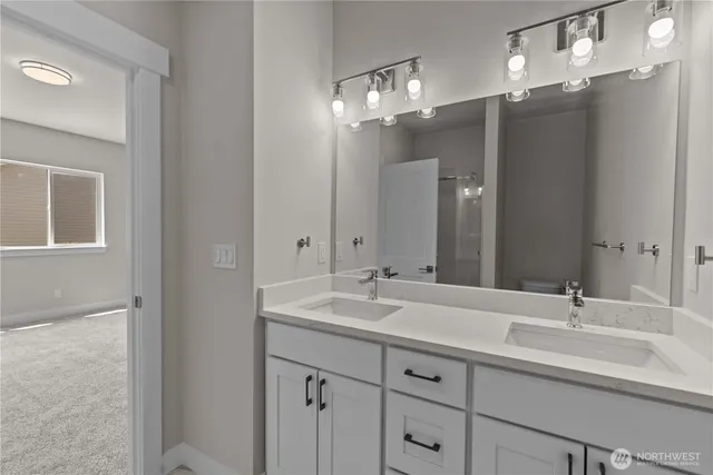 a bathroom with double vanity sinks and a mirror