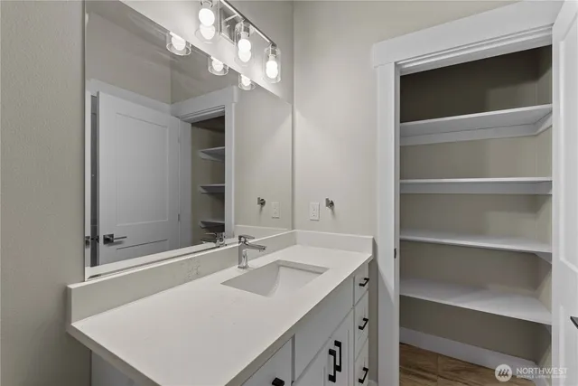 a bathroom with a sink vanity and a mirror