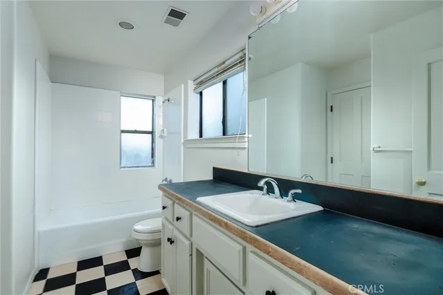 a bathroom with a double vanity sink a mirror and a bathtub