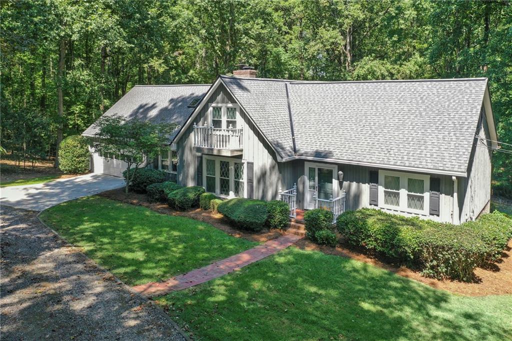 a aerial view of a house next to a big yard and large trees