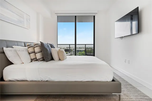 a large bed sitting in a bedroom next to a window