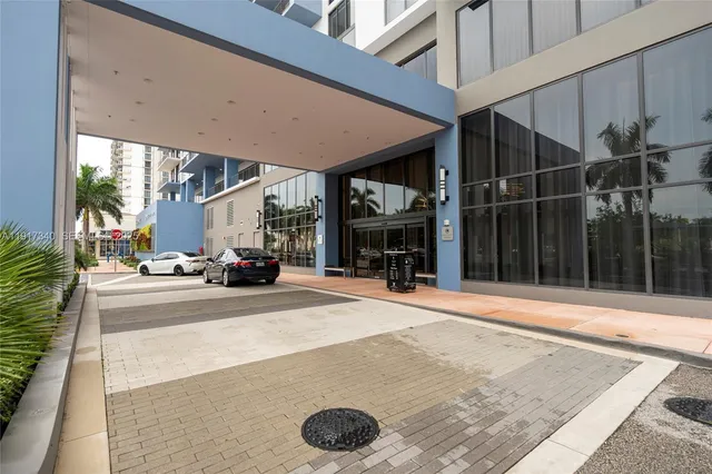 a view of a house with a floor to ceiling window and potted plants
