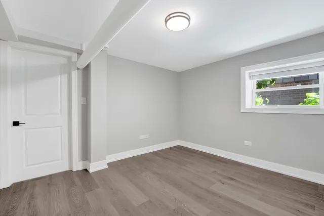 an empty room with wooden floor and window