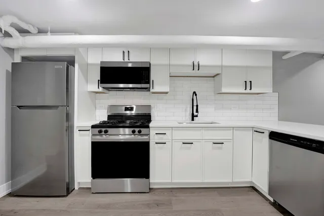 a kitchen with cabinets stainless steel appliances and a sink