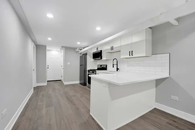 a view of kitchen with stainless steel appliances cabinets and wooden floor