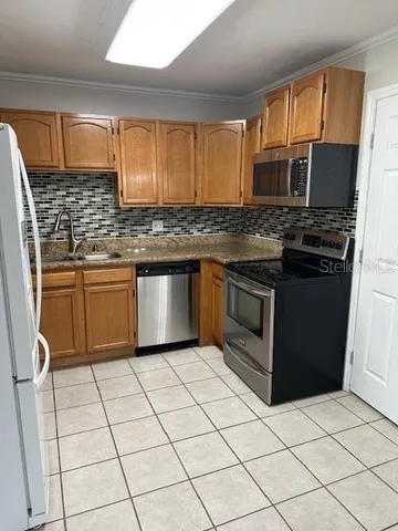 a kitchen with stainless steel appliances granite countertop a stove a sink and a microwave