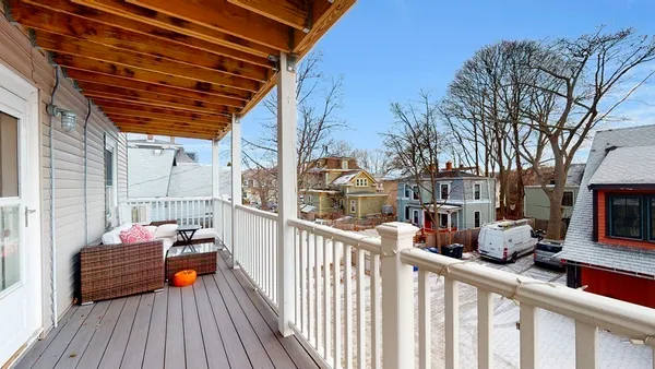 a view of balcony with wooden floor and seating space