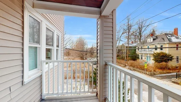 a view of a balcony with wooden floor and fence