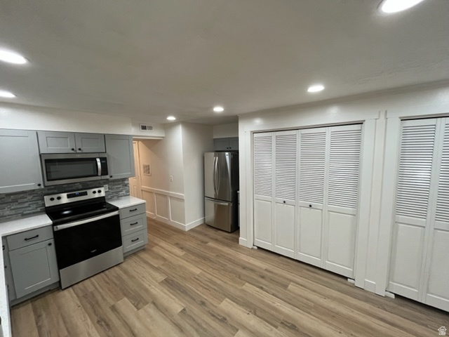 6884 670 East Midvale, UT 84047 - Photo 3 of 28 Kitchen featuring gray cabinetry, stainless steel appliances, light wood-style flooring, decorative backsplash, and recessed lighting