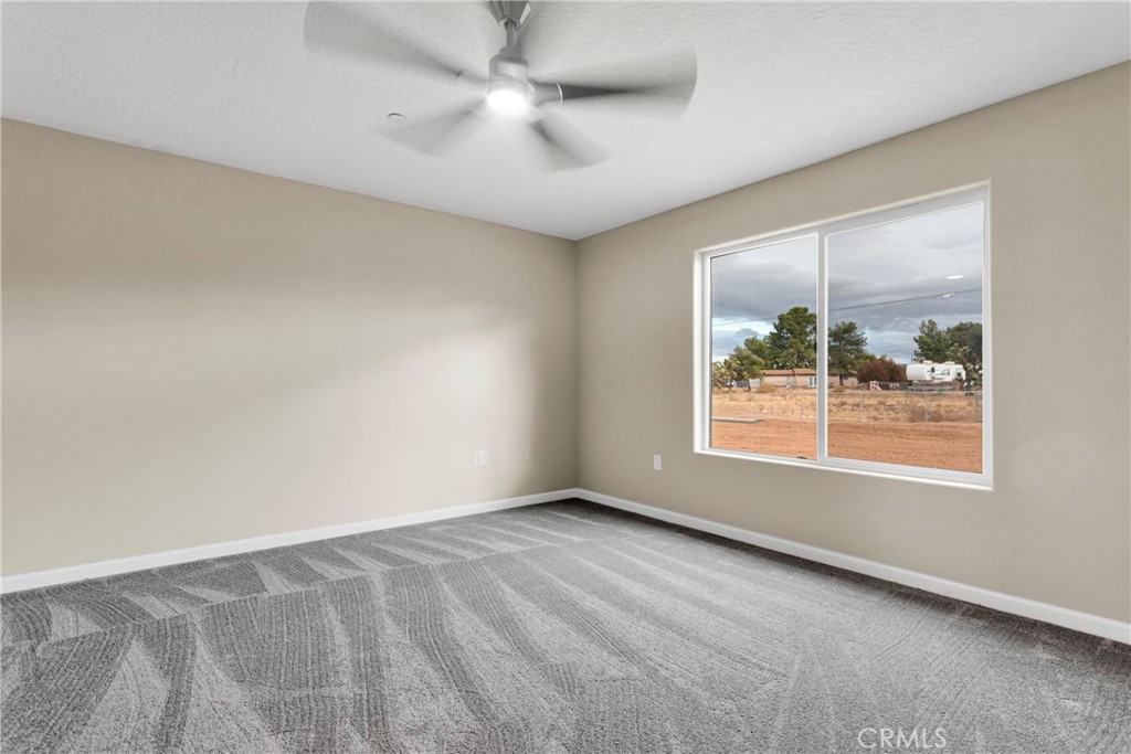 19375 Corwin Road Apple Valley, CA 92307 - Photo 18 of 27 an empty room with a window and a fan