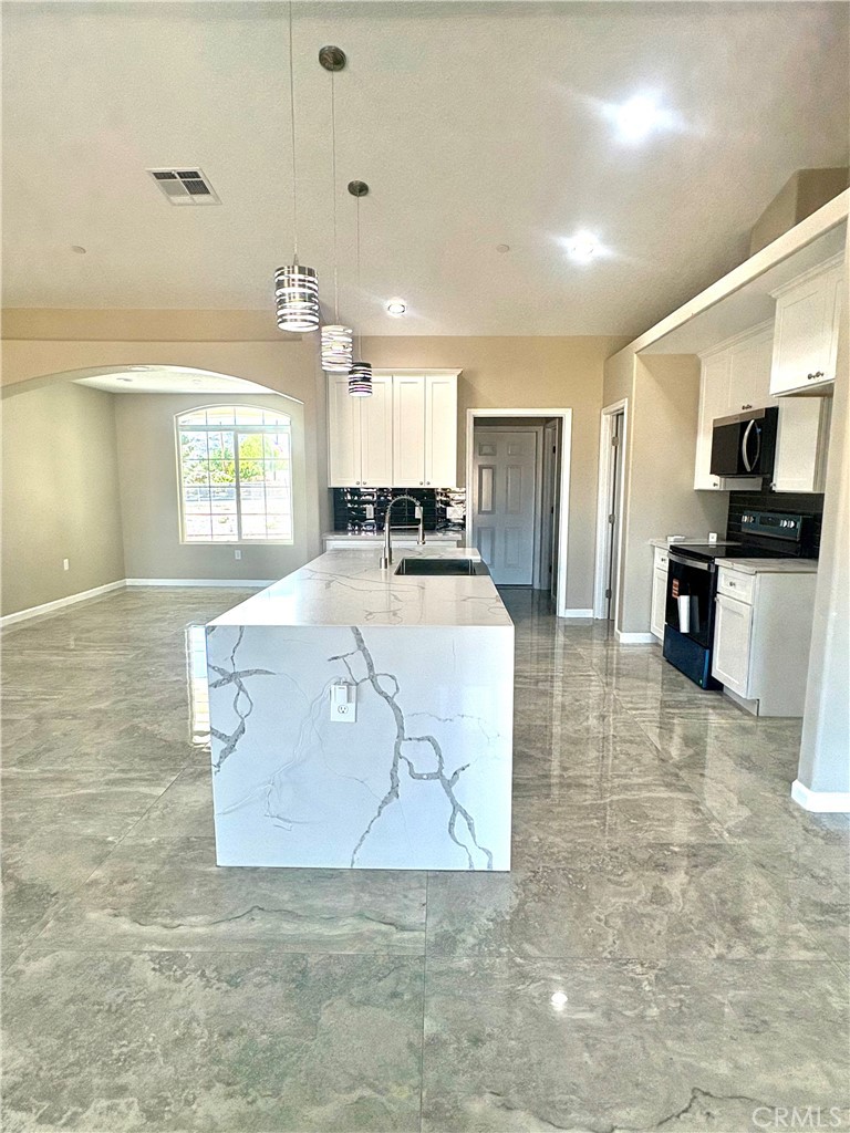 19375 Corwin Road Apple Valley, CA 92307 - Photo 3 of 27 a large kitchen with kitchen island a stove a sink a counter space and cabinets