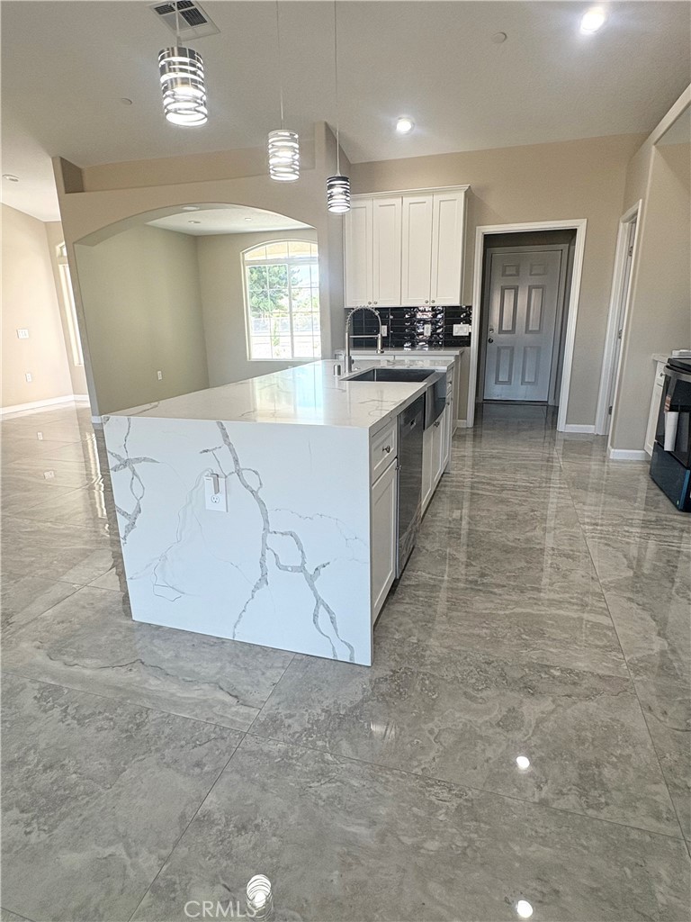 19375 Corwin Road Apple Valley, CA 92307 - Photo 4 of 27 a large kitchen with kitchen island granite countertop a stove a sink a refrigerator white cabinets and wooden floor