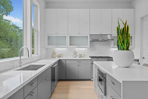 a kitchen with stainless steel appliances granite countertop a sink a stove and a white wooden cabinets