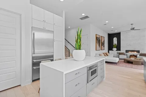 a kitchen with stainless steel appliances granite countertop a refrigerator a stove and a sink