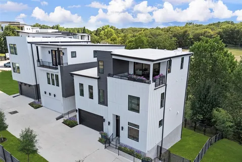 a view of a white house next to a yard