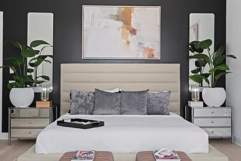 a bedroom with a bed a potted plant and a window