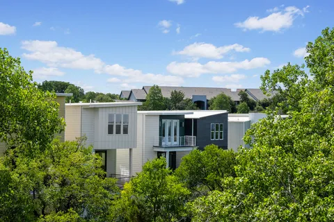a view of a house with a yard and potted plants