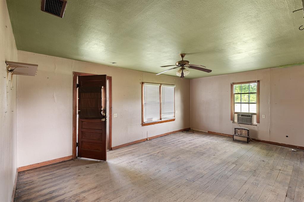 201 Proctor Lane Sunset, TX 76270 - Photo 14 of 18 an empty room with windows and a ceiling fan