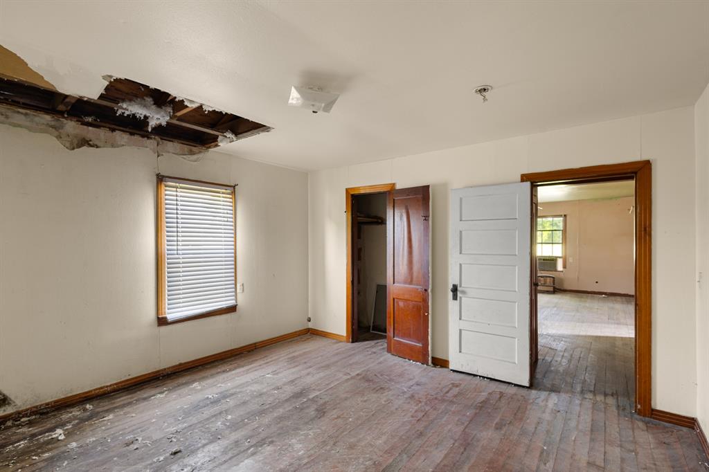 201 Proctor Lane Sunset, TX 76270 - Photo 9 of 18 an empty room with wooden floor windows and a ceiling fan