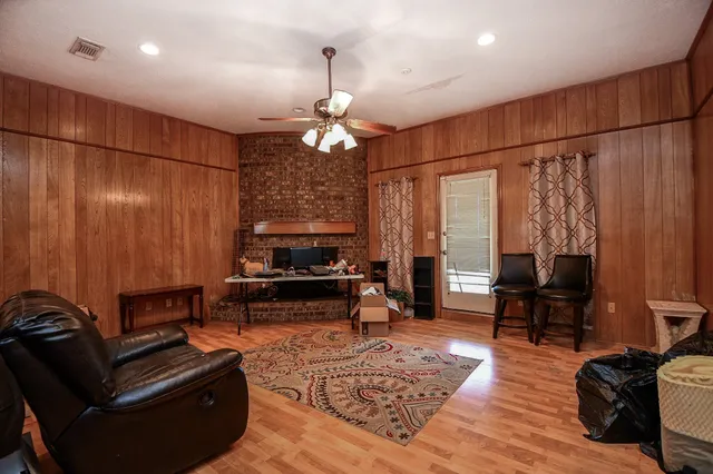 a view of swimming pool with lawn chairs and large trees