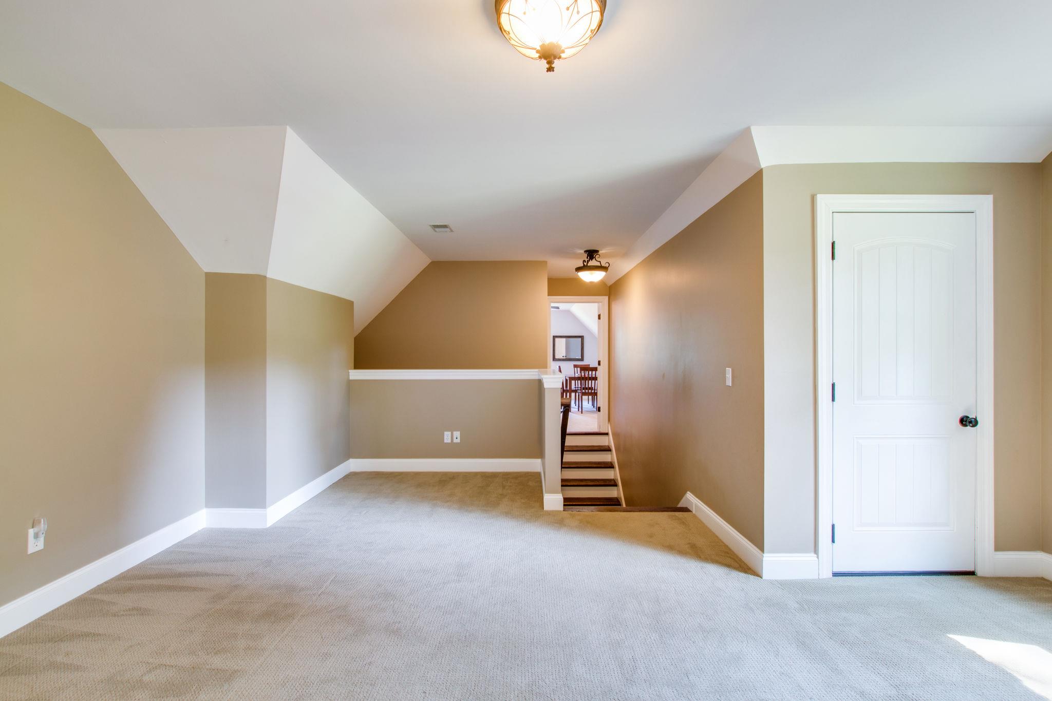 6629 Burnt Knob Road Murfreesboro, TN 37128 - Photo 21 of 27 Another HUGE walk-in closet! Those stairs come up from the garage door entrance. It splits to the left to the bonus room with the red furniture; and to the right with all this open space!