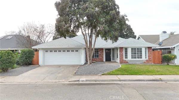 a front view of a house with a garden and garage