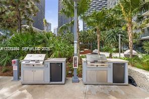 88 Southwest 7th Street, Unit 2210 Miami, FL 33130 - Photo 19 of 24 Outdoor BBQ grill area surrounded by tropical landscaping.