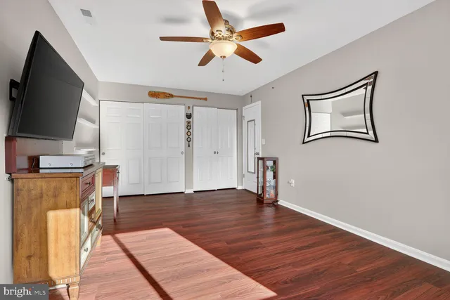 a view of a livingroom with furniture a flat screen tv and wooden floor