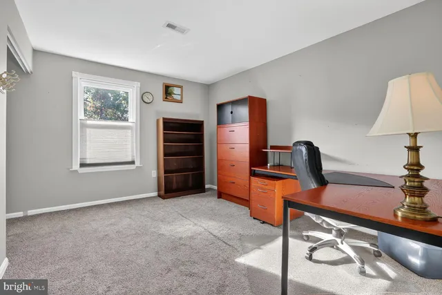 a view of an empty room with wooden floor and a ceiling fan