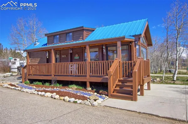 a view of a house with a small yard and wooden fence