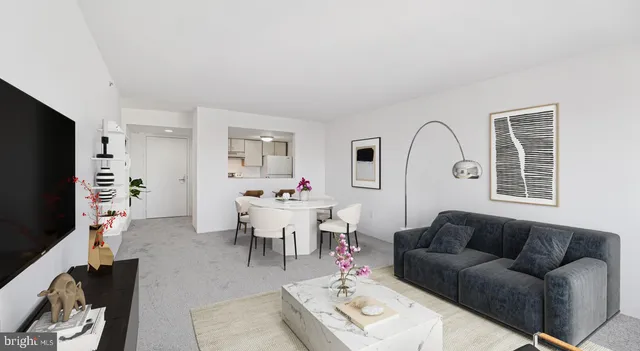 a living room with furniture a rug a flat screen tv and a window