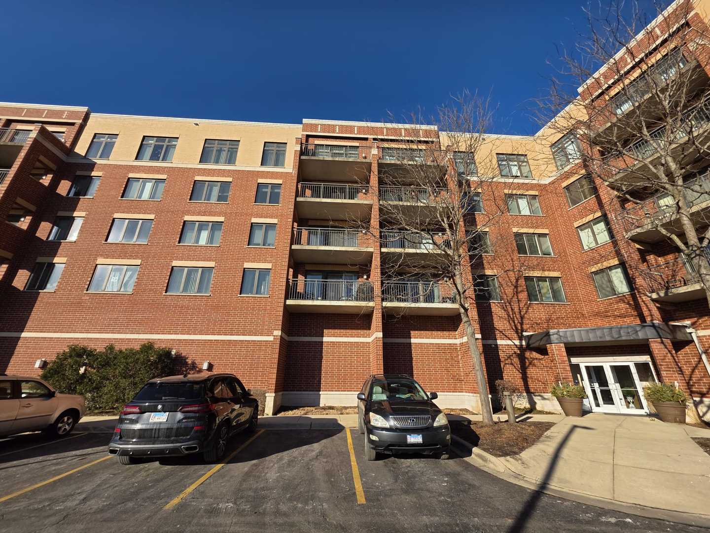 225 Main Street, Unit 210 Roselle, IL 60172 - Photo 1 of 31 a front view of a building with parking space and a car parked on the side of it