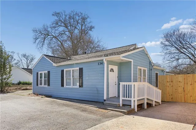 a view of a house with a yard and wooden fence