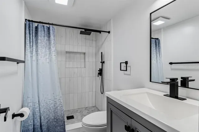 a bathroom with a sink a toilet and shower