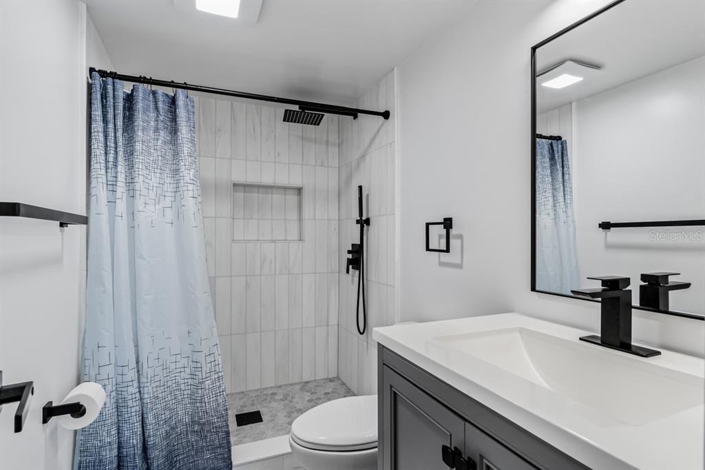 3210 Gulf Boulevard, Unit 307 Belleair Beach, FL 33786 - Photo 19 of 44 a bathroom with a sink a toilet and shower