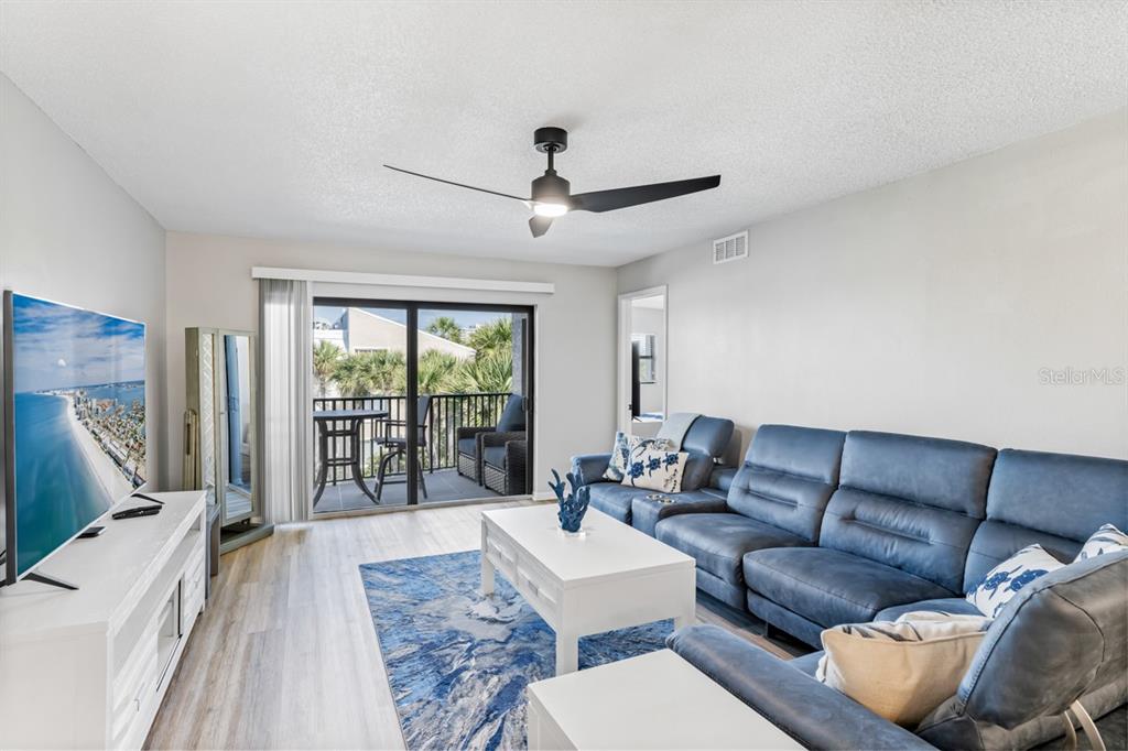 3210 Gulf Boulevard, Unit 307 Belleair Beach, FL 33786 - Photo 6 of 44 a living room with furniture a ceiling fan and a rug