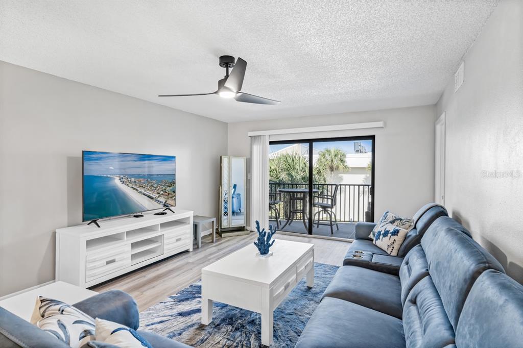 3210 Gulf Boulevard, Unit 307 Belleair Beach, FL 33786 - Photo 7 of 44 a living room with furniture and floor to ceiling window