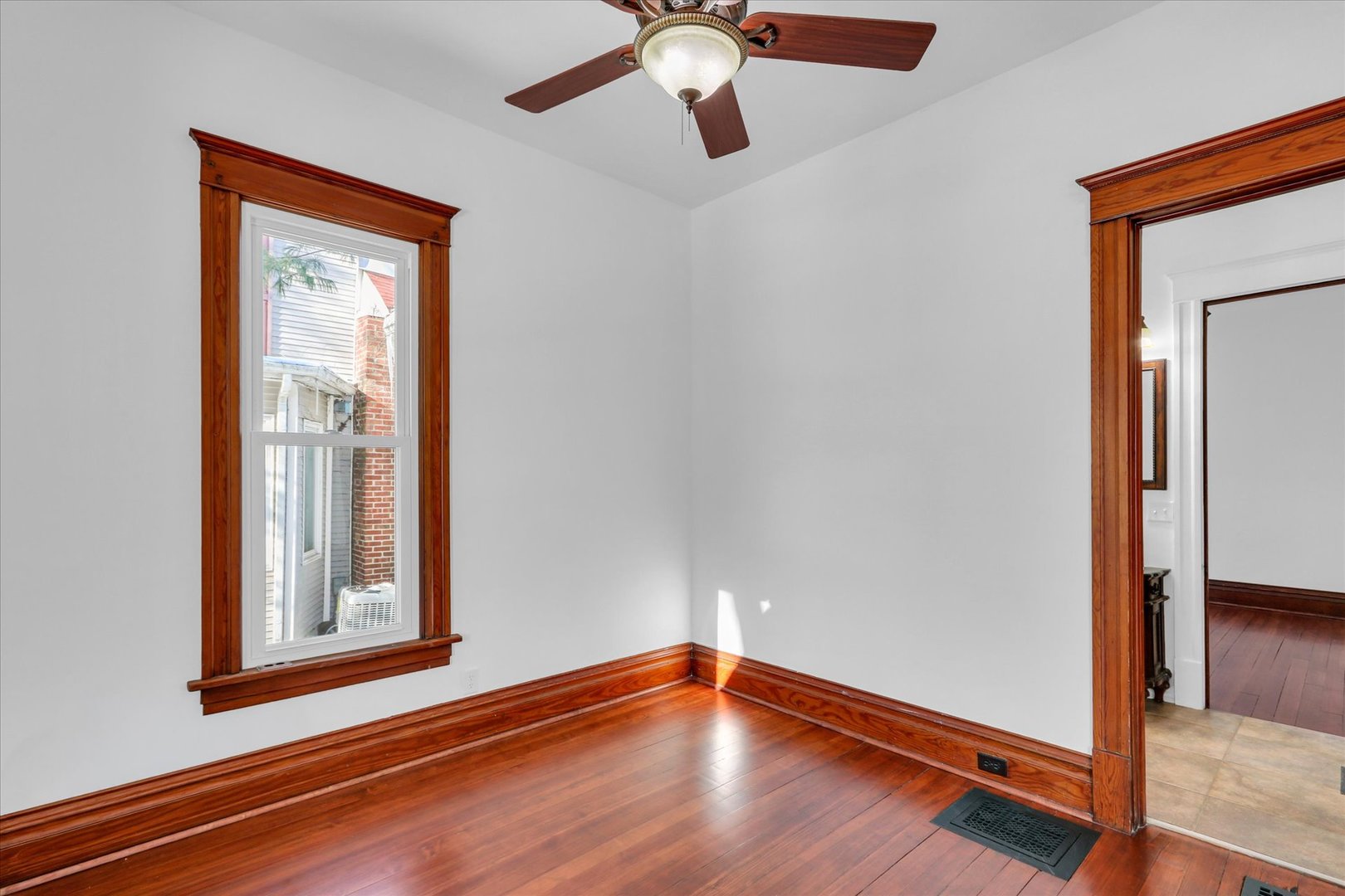 202 East Daggy Street Tuscola, IL 61953 - Photo 16 of 45 a view of an empty room with window and wooden floor