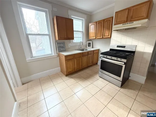 a kitchen with granite countertop a stove a sink and a microwave