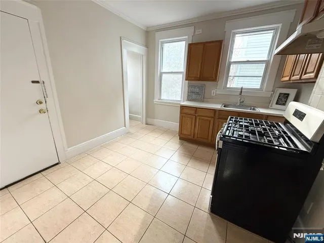 a kitchen with granite countertop a stove a sink and a refrigerator