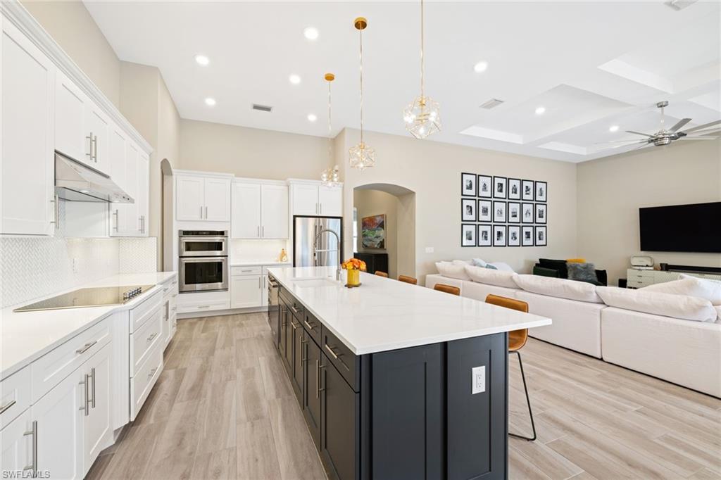 19134 Elston Way Estero, FL 33928 - Photo 12 of 35 a large room with kitchen island a sink a counter space and stainless steel appliances