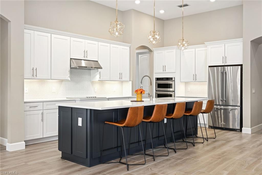 19134 Elston Way Estero, FL 33928 - Photo 14 of 35 a kitchen with stainless steel appliances granite countertop a refrigerator a stove and white cabinets