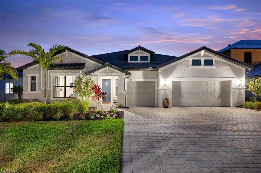 19134 Elston Way Estero, FL 33928 - Photo 2 of 35 a front view of a house with a yard and potted plants