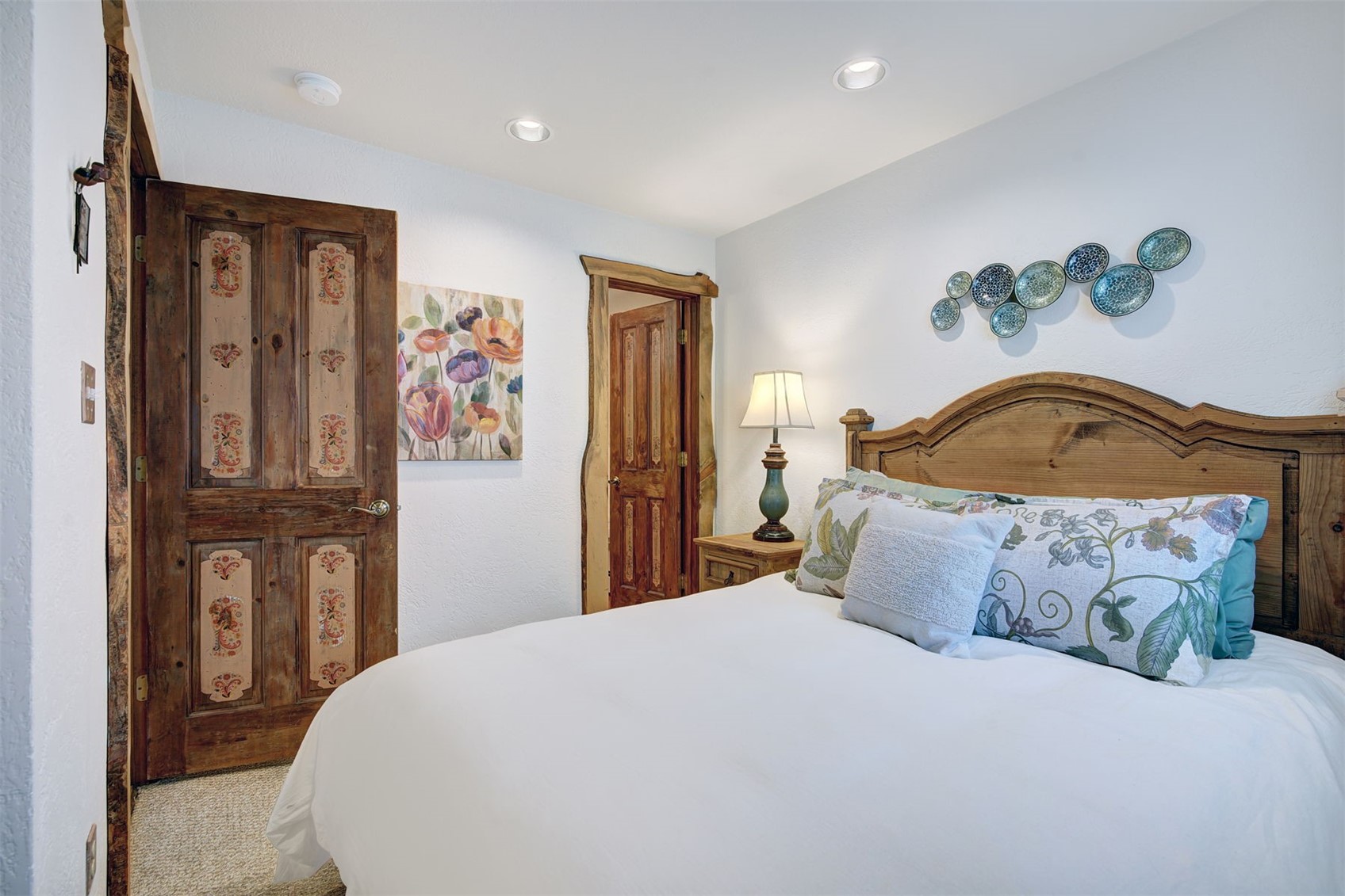 9460 Ryan Gulch Road, Unit 9460 Silverthorne, CO 80498 - Photo 24 of 39 a bedroom with a bed and dresser with mirror