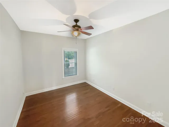 an empty room with a window and a ceiling fan