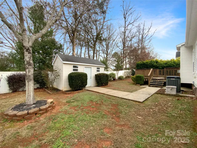 a view of a house with backyard and a tree